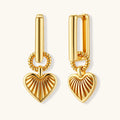 Gold-plated huggie earrings with textured heart charms featuring radiating sunburst patterns on white background.