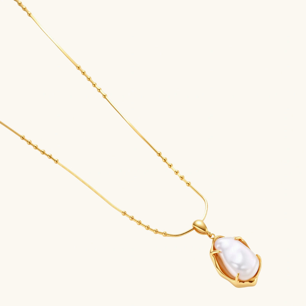 18K gold-plated sterling silver necklace with alternating bead chain and baroque pearl pendant on neutral background.