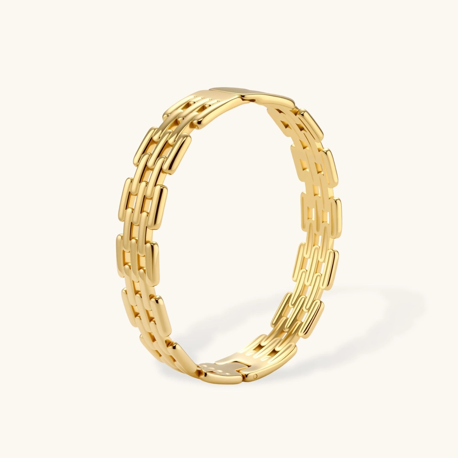 Wide 18K gold plated stainless steel bracelet with a multi-row rectangular grid link chain pattern on a cream background.