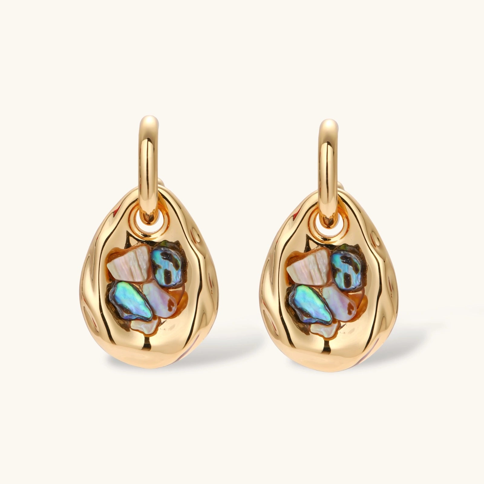 Gold-plated convertible hoop earrings with iridescent shell mosaic pendants, shown assembled and separated on cream background.